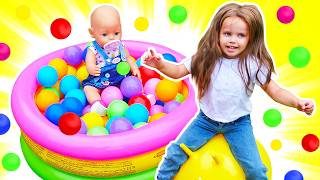 Maya is building a new play area for their doll, complete with a slide, a ball pit, and toys.