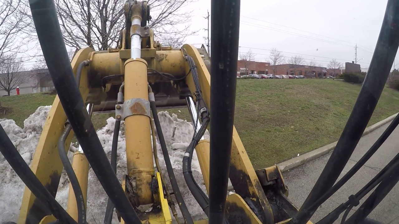Cat loader snow relocation on industrial site series - YouTube