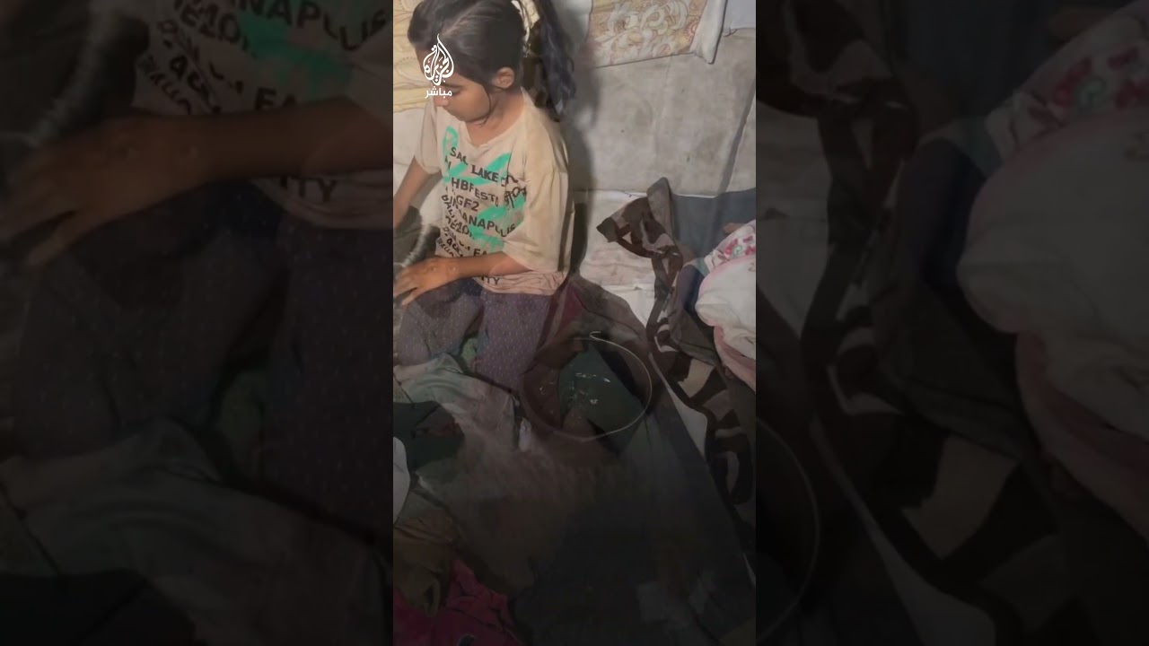 طفلة فلسطينية تحاول جمع مياه الأمطار عقب تسربها من خيمة للنازحين جنوبي قطاع غزة