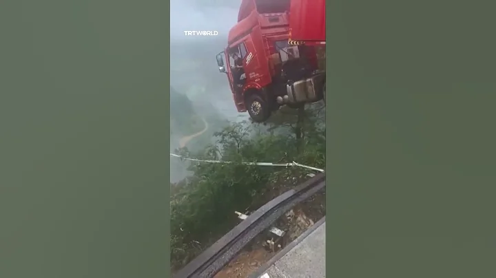 Driver trapped inside truck hanging precariously over the edge of a collapsed bridge