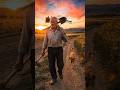 A farmer carrying tools on his shoulder, walking through fields as the sky turns orange #shorts