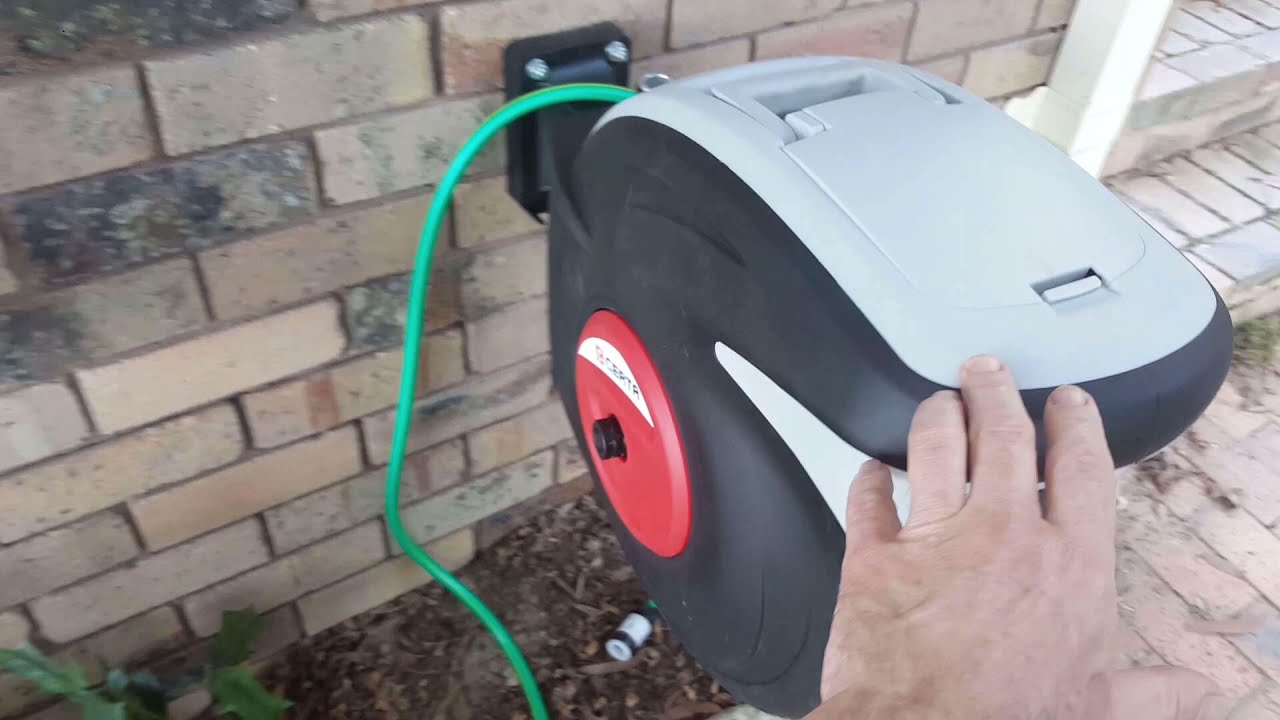 Install anchor bolts and a hose reel on brick wall 