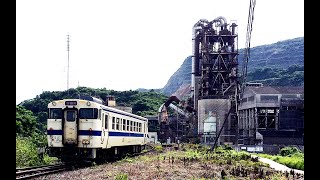 セメント工場を行く列車、踏切で舞い上がる白い粉