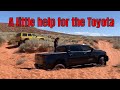 Jeep helps Toyota Tundra out of sand trap.