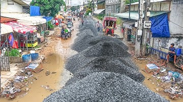 New operating road construction in village spreading gravel by expert dozer push & large dump truck