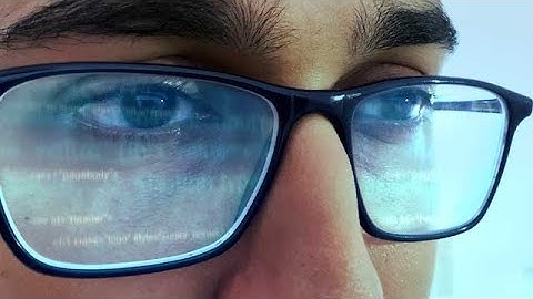 Man looking at programming code reflecting in his glasses stock footage | stock video | Cinefootage