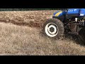 Tractor New Holland tt75 FWD barbechando con arado Famaq ADH-300 de 3 discos dentados.