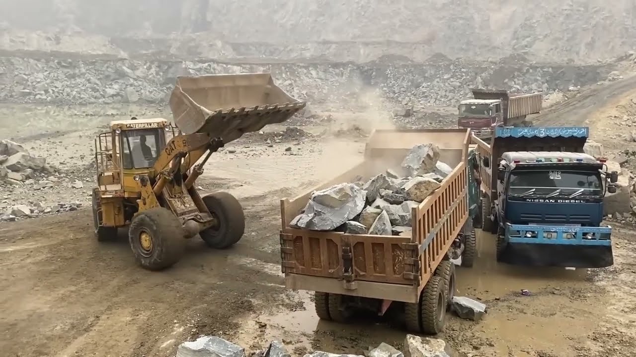 Caterpillar 966D Loader Hard Working Loading Huge Rocks into Dump Truck