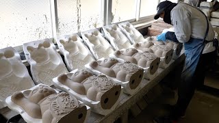 The process of mass-producing maneki-neko (Japanese lucky cats) in Japan.