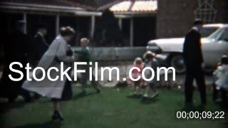1957: Catholic priest supervising an Easter egg hunt in the church courtyard. DENVER, COLORADO