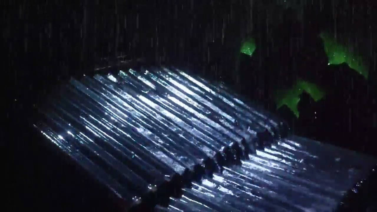 Heavy rain on the zinc roof of the old house, in the dark forest