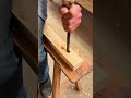 chiseling a precise rectangular hole into a piece of timber using a sharp hand tool and mallet
