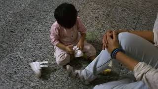 One Year Old Daughter Trying Her Shoes In Mothers Feet