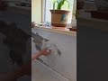 plastering smooth cement on the walls under the windows of the upper floors of a multi-storey