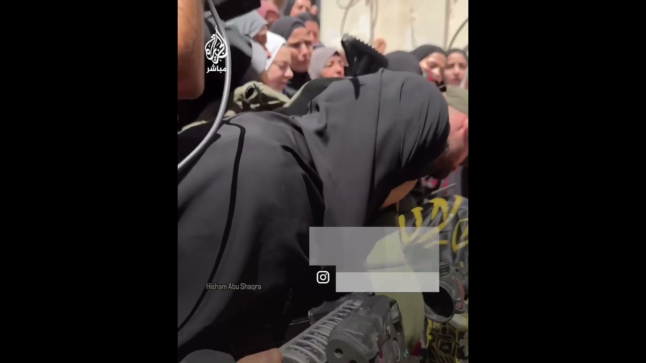 ‌بصبر وصمود.. شقيقة الشهيد محمد شحادة تقبل قدميه وبندقيته أثناء وداعه في مخيم نور شمس بمدينة طولكرم