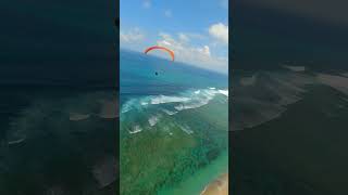 Fpv Shot Of Paragliders Gliding Over Turquoise Ocean And Beach