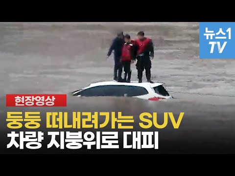 둥둥 떠내려가는 SUV...차량 지붕위로 대피한 아버지와 아들