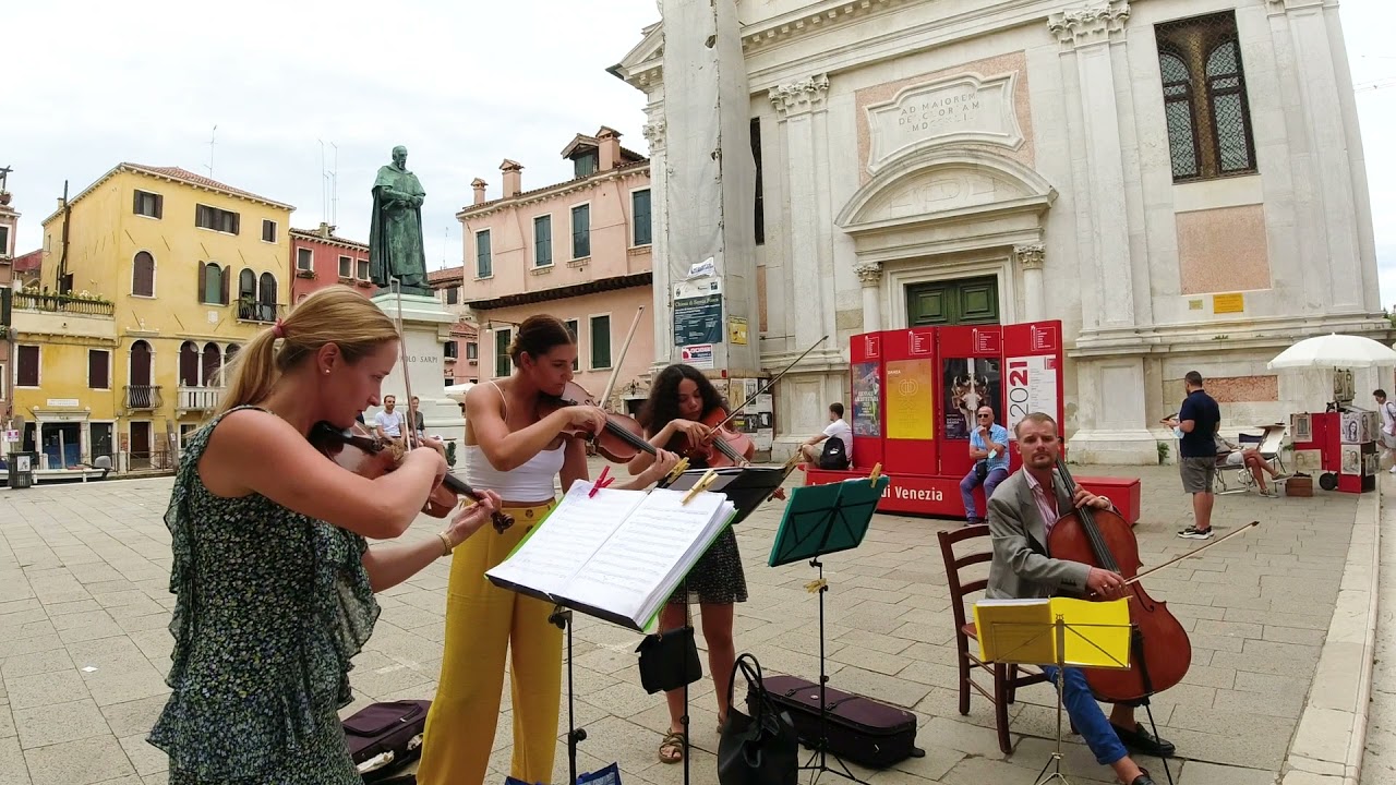 Street string orchestra plays pirates of carribean theme on the streets of Venice