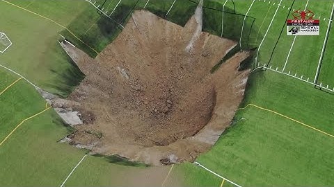 Surveillance video shows the moment when a 100-feet-wide sinkhole swallows a soccer field
