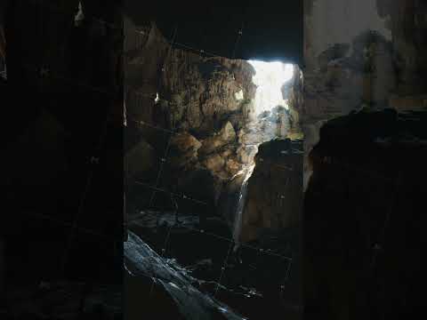Sunbeam shines through cavern opening in remote jungle cave in Laos, Southeast Asia, creating