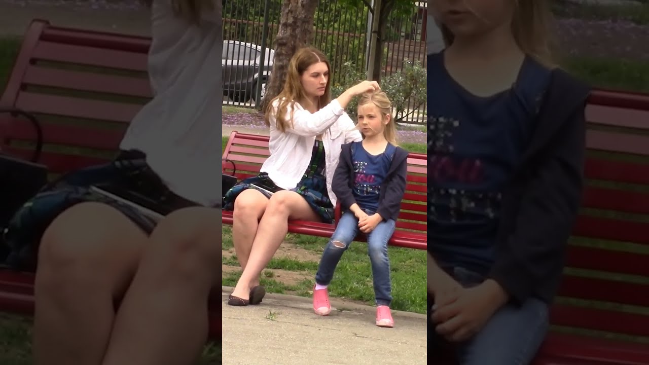 Kind Woman Helps Little Girl Tie Her Hair Shorts