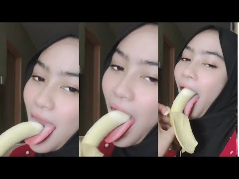 Hijab Girl Shows Off The Action Of Eating A Seductive Banana While Jolok Is Forced By A Man