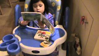 Toddler re-vists high-chair to read books to herself