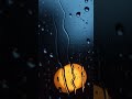 Rainy window with warm lamp glow and drifting raindrops at night 🌧️