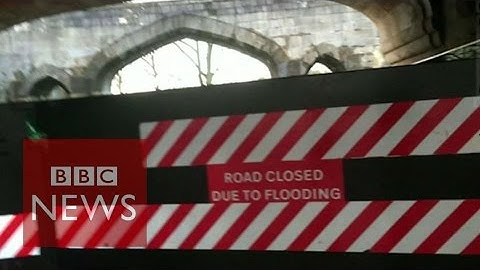 Filming over a flood gate as water rises in York - BBC News