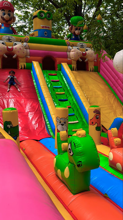 Little brother playing on the red track slide at the super minion balloon palace ride