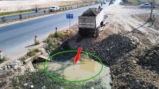 Neat dumping dump trucks and Komatsu Bulldozer push stones and soil to filling up land