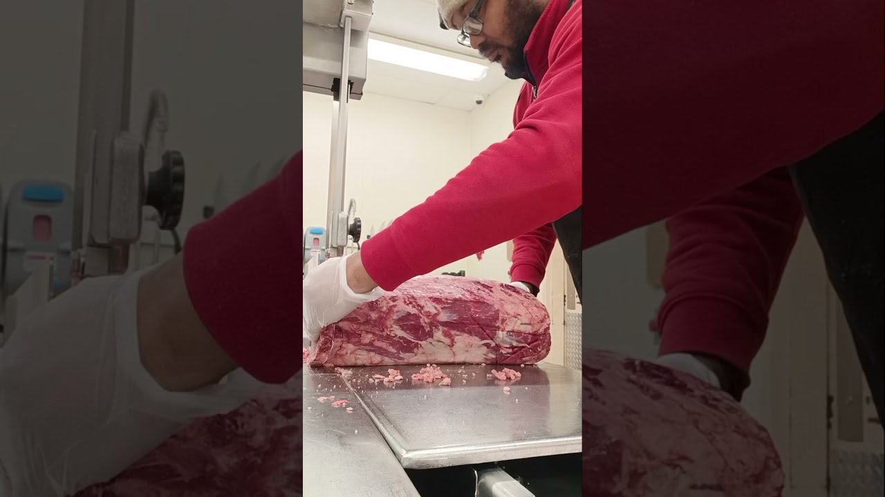 Cutting some bone-in ribeye to on the saw at work 