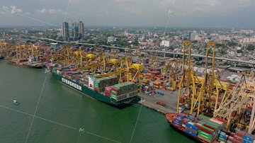 Monstrous overseas cargo ships in harbour. Aerial view of container terminal in seaport. Buildings
