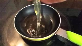 Slow motion of egg dropping in pan