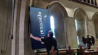 Practical AV completing the installation of a 75" screen, cabling and a networked video signal.