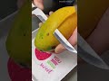 textcutting a ripe yellow mango into two large halves using a sharp kitchen steel knife tool indoors