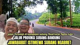 Behind the smooth road there is a beautiful view of the Subang Bandung provincial route in the er...