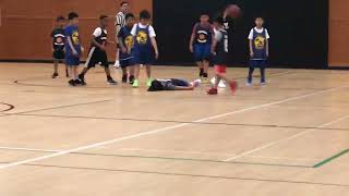 Boys playing basketball at gym then one kid steals the ball from the other and he flops to the floor