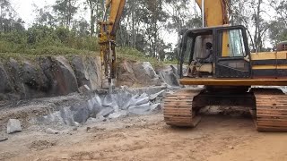 330 caterpillar excavator with hydraulic jackhammer breaking rocks