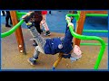 Cute young boy hanging upside down on a kids playground in public park. Activity for children.