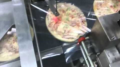 Automated shrink wrap machine and high speed pizza and baked goods shrink wrapping