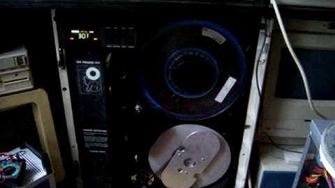 Old 9-track tape drive and 10,5 inch magnetic tape.