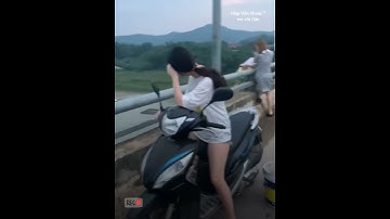 Hot girl dừng xe máy trên cầu đổ rác xuống sông