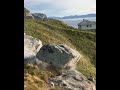 Guys drop big huge stone from hill cliff into sea