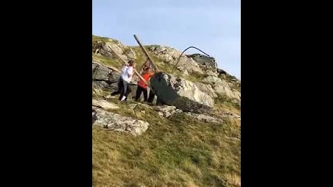 guys drop big huge stone from hill cliff into sea