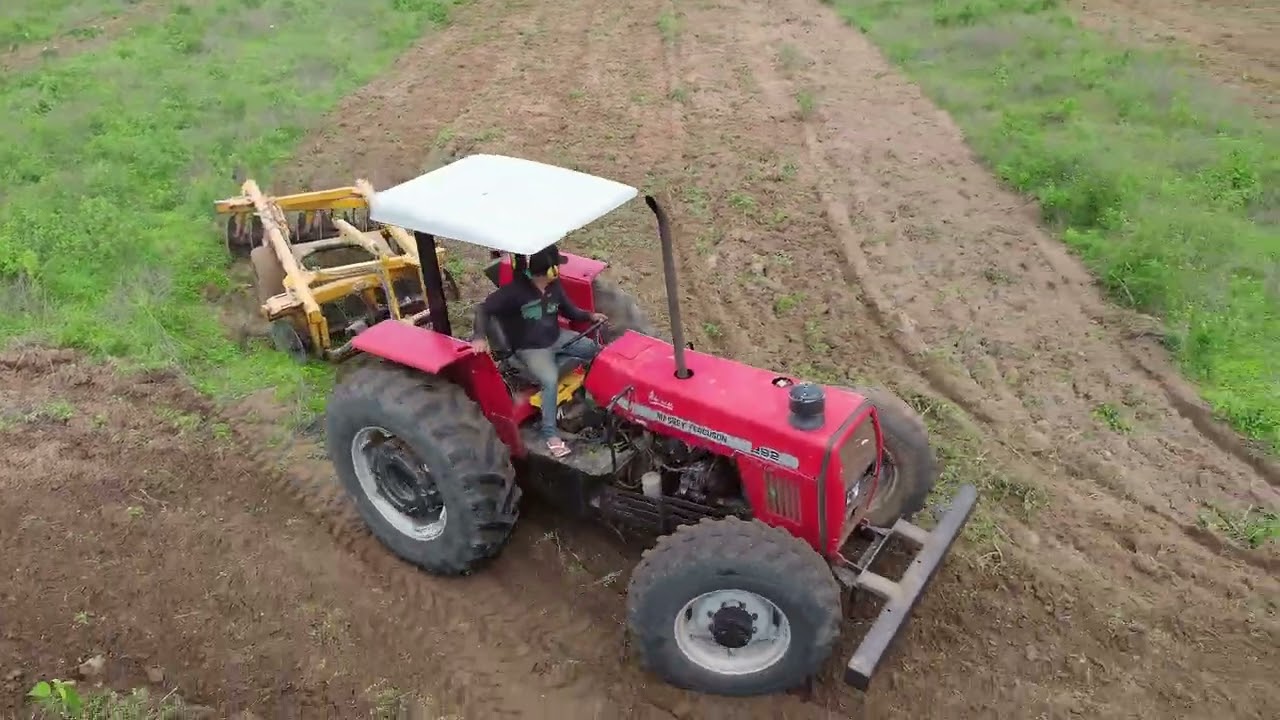 Trator MF292 grande ando a terra para o plantio de capim e milho