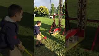 Kid hits himself in the leg with a hammer trying to play a game at the carnival