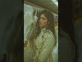 A realistic cinematic animation based on a photo of a young woman with voluminous curly brown hai...