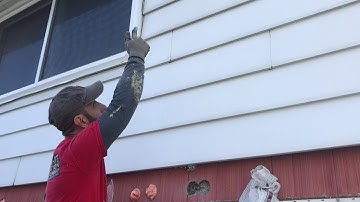 Blowing insulation in the sidewall of a house