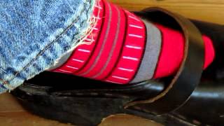 A Black Clog And A Red Striped Sock